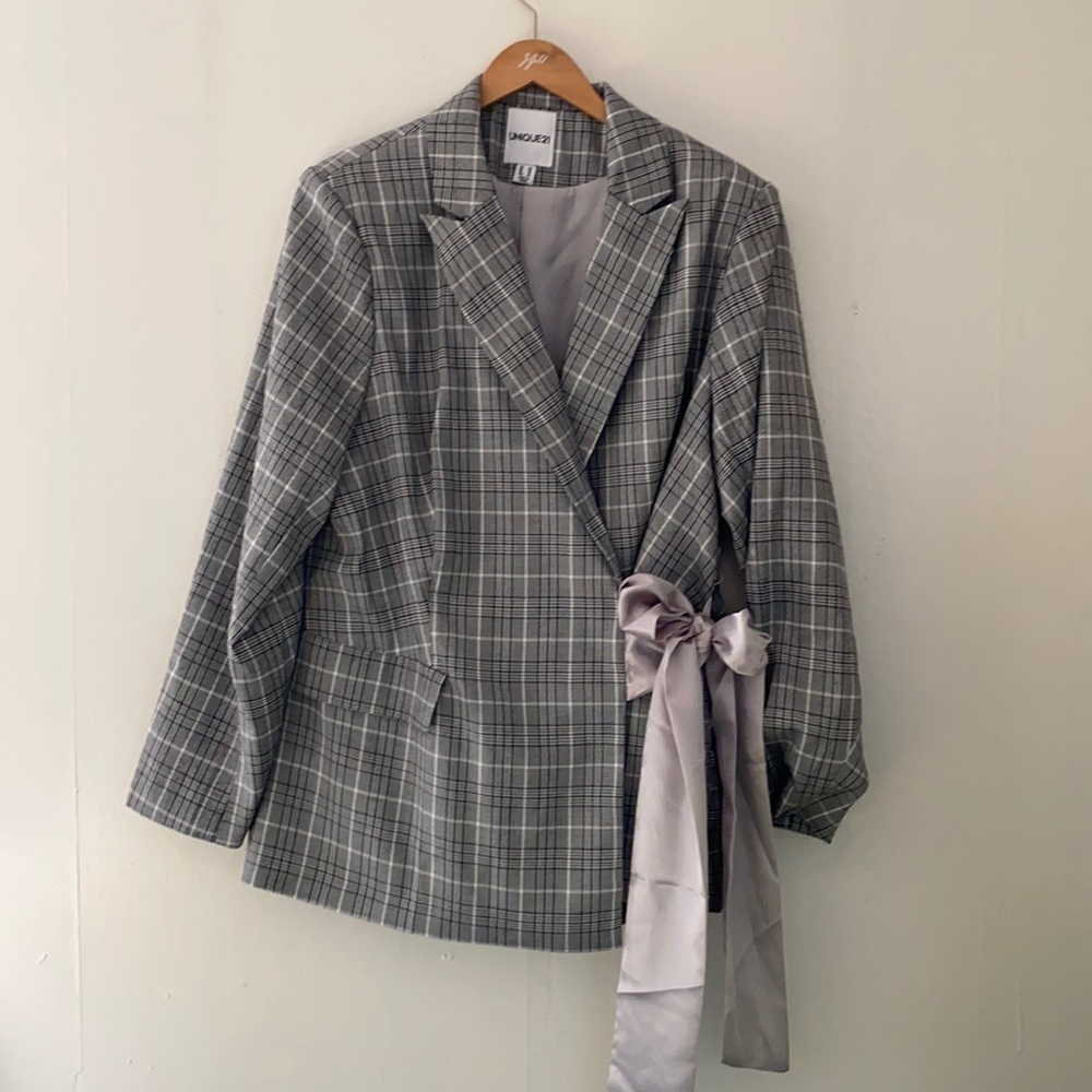 Silk tie front of laid blazer
